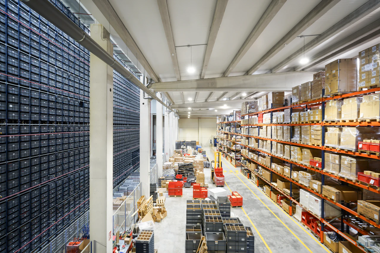 Responsable logistique préparant un projet d’aménagement d’entrepôt en Martinique devant un plan de stockage